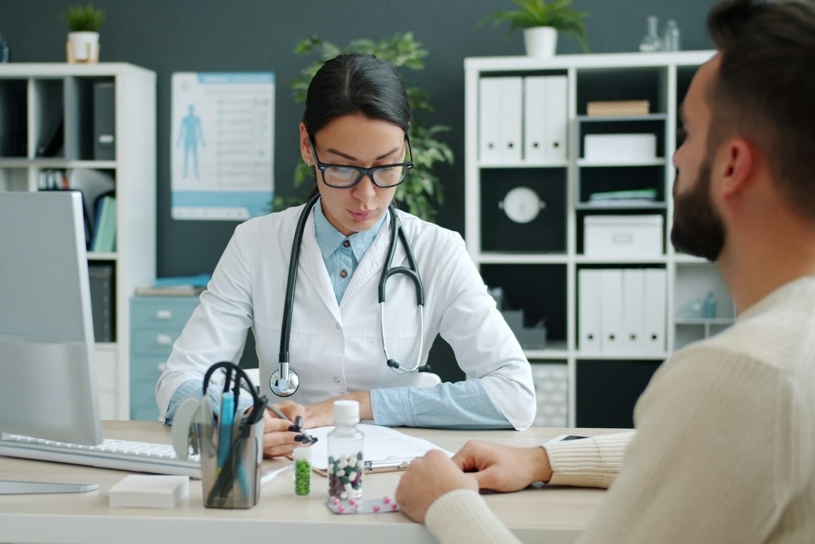 Doctor consulting with a patient at a desk.