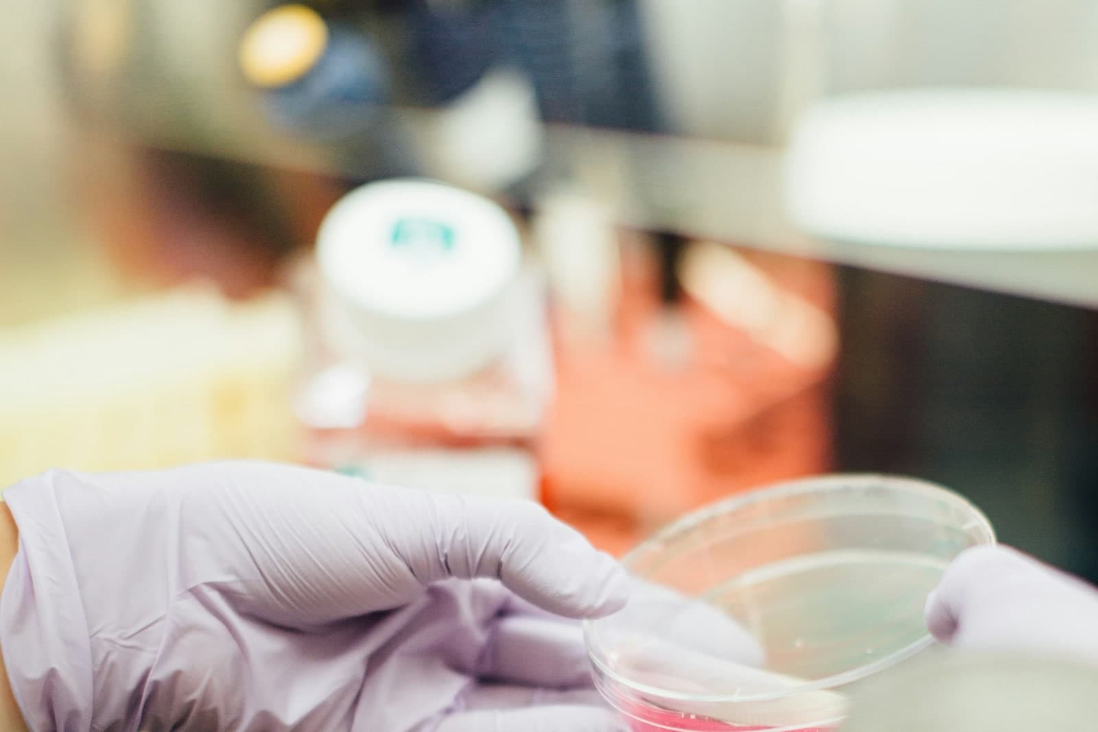 Scientist holding a petri dish, representing quality and evidence controls.