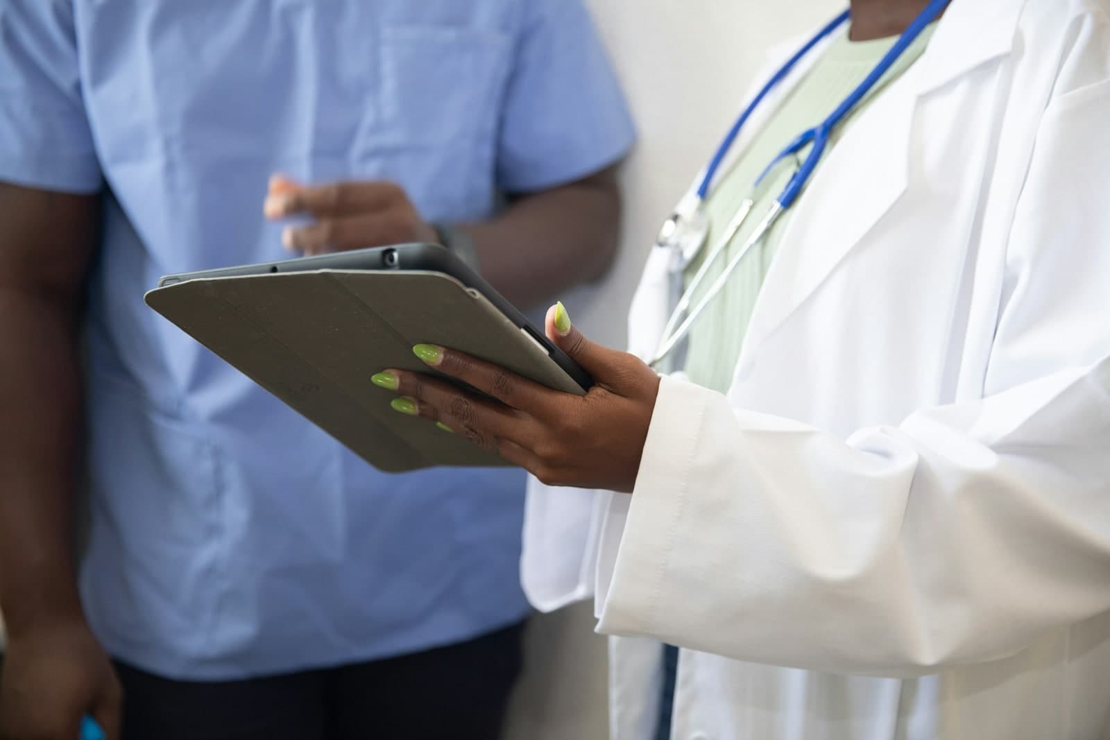 Clinician and patient reviewing information on a tablet in a care setting.